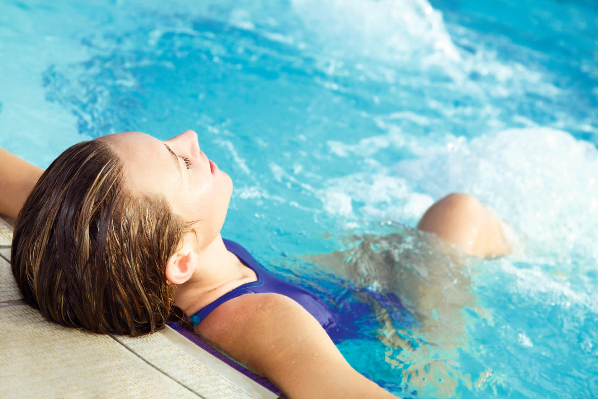 Eine Schwimmerin erholt sich am Beckenrand